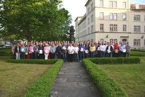 etwa 100 Personen vor Brunnen, Schloss Sonnenstein im Hintergrund 