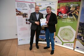 zwei Personen mit Blatt in der Hand