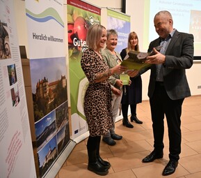 Person übergibt Urkunde an andere Person