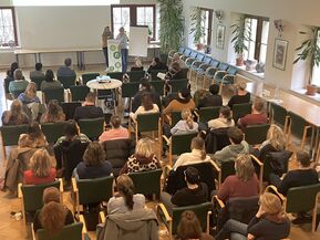 Personen hören einem Vortrag zu