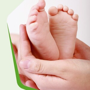 Bild: Erwachsenenhand hält Kinderfüße