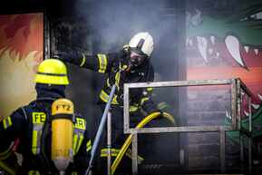 Brandübungscontainer mit Feuerwehrleuten