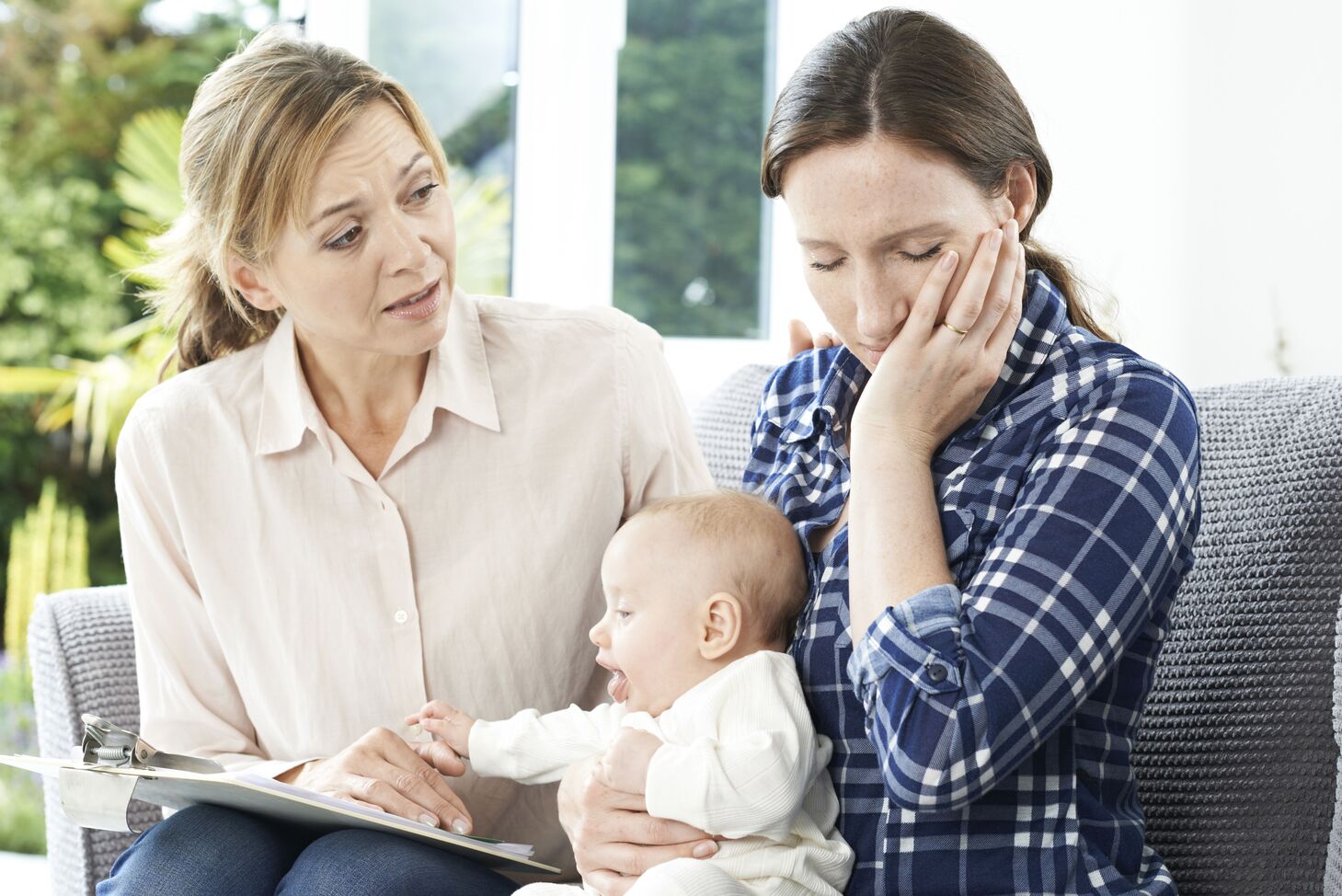 Besorgte Mutter hält Baby auf Schoß