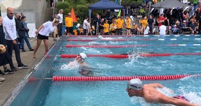 Schwimmer in Pool mit Zuschauern am Rand