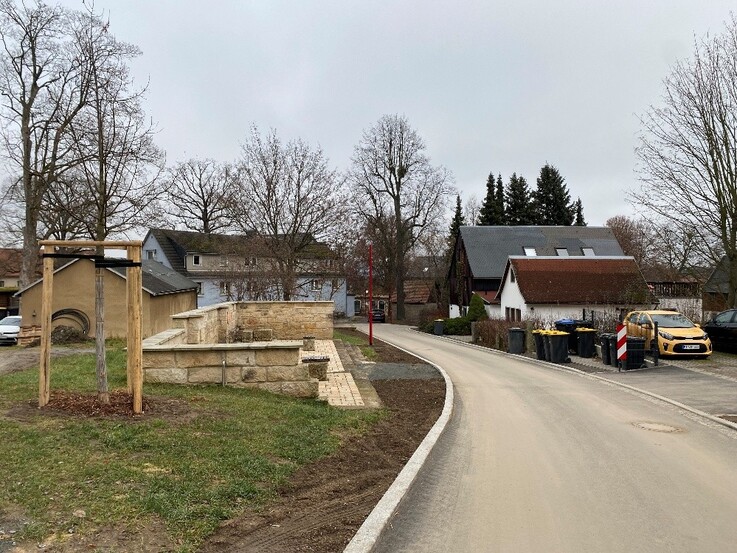 Neu ausgebaute Straße mit einer Sitzgelegenheit aus Sandsteinen