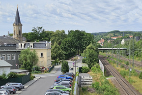 Freital Blick auf Fußgängerbrücke, links Autos, rechts Bahnschienen