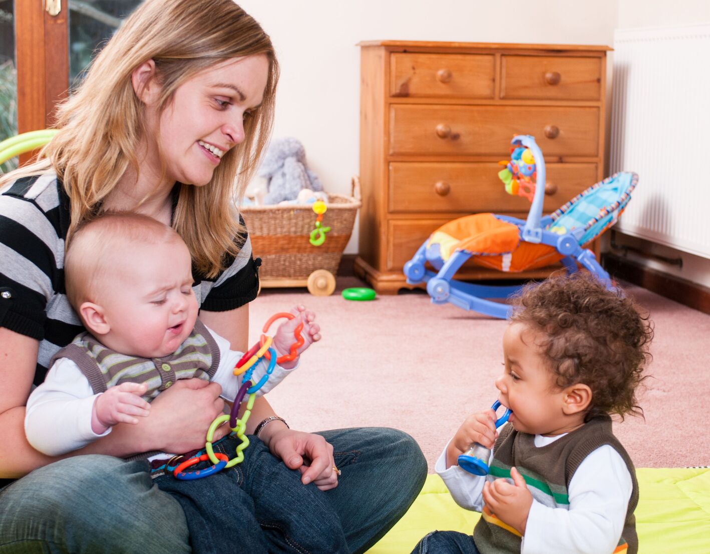 Tagesmutter spielt mit zwei Kindern